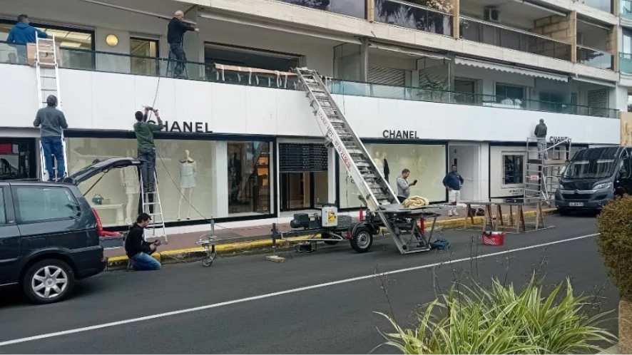 Matériel et intervenants devant la façade de commerces